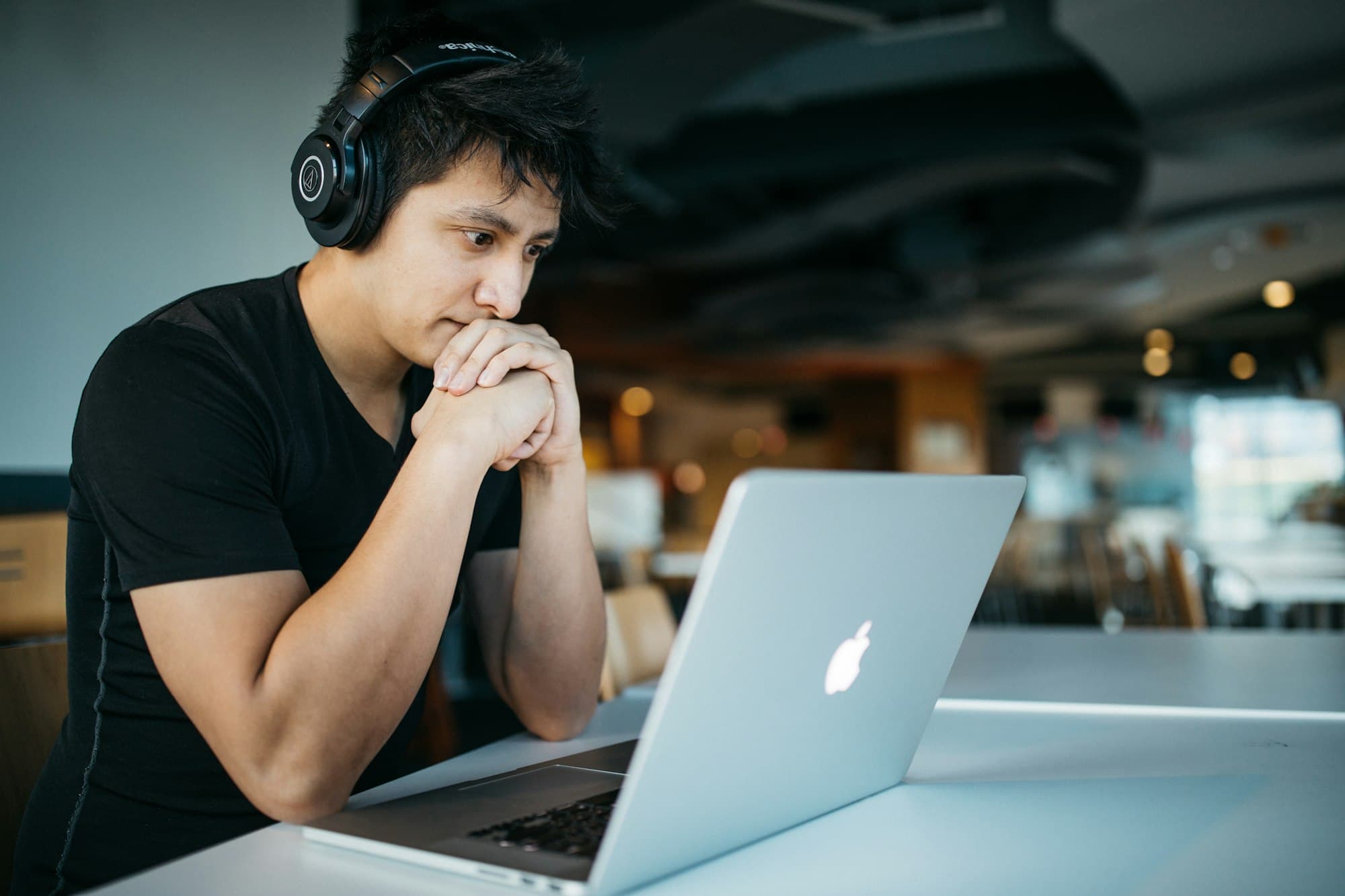 A student in headphones concentrating on a laptop