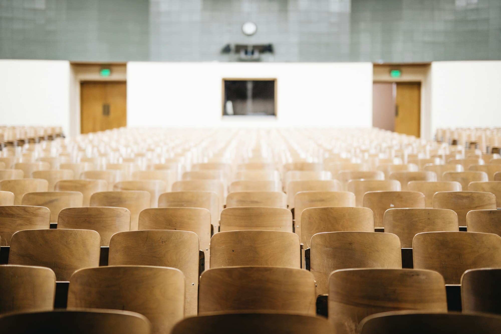 An empty lecture theatre with rows of wooden seats