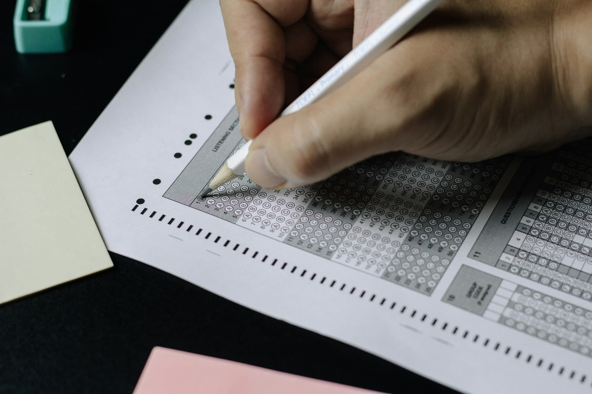 Close-up of a hand filling in a multiple-choice exam answer sheet